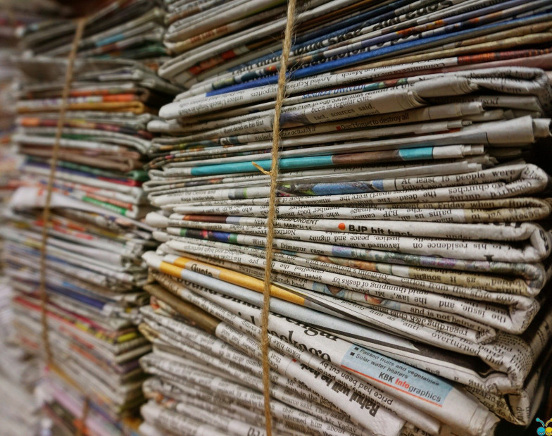 Photo of a stack of newspapers tied together with string