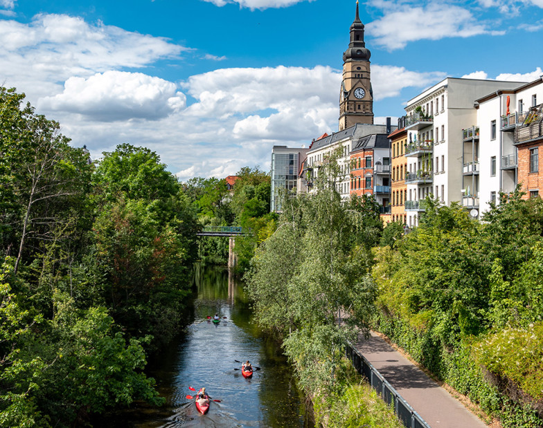 Fluss durch Stadt mit Kajaks.
