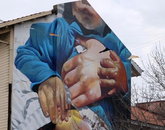 Foto: Grafito eines Kindes, das mit seinen Händen die Hand eines Erwachsenen umschließt