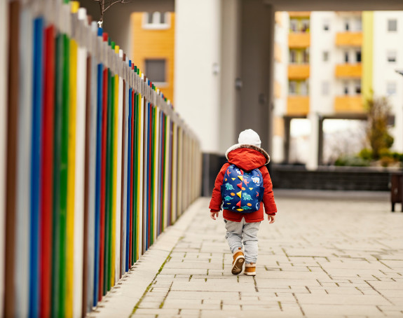 Ein Kind läuft alleine einen Weg entlang